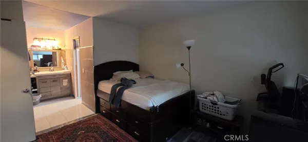 a bedroom with a bed and a dresser next to a window