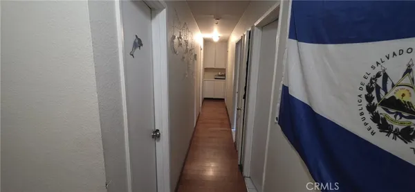 a view of a hallway with wooden floor and stairs