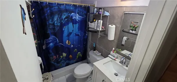 a bathroom with a toilet and shower curtain