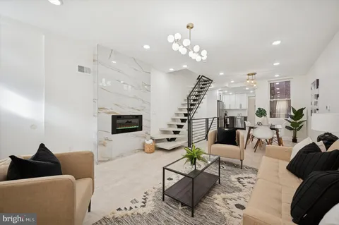 a living room with furniture and a chandelier