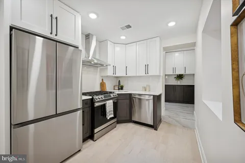 a kitchen with stainless steel appliances granite countertop a refrigerator a sink and a stove