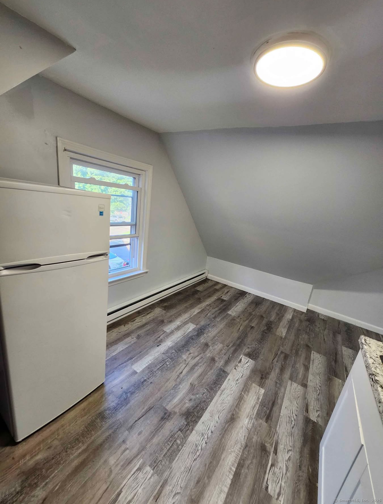 101 Goddard Avenue, Unit 3 Bridgeport, CT 06610 - Photo 2 of 6 a view of a room with wooden floor and a refrigerator