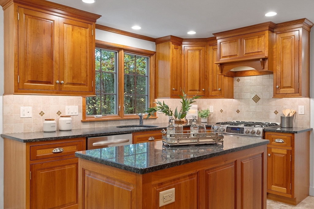 31 Herrick Road Boxford, MA 01921 - Photo 8 of 40 a kitchen with kitchen island granite countertop a sink stainless steel appliances and cabinets