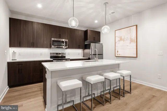 a kitchen with kitchen island wooden cabinets and refrigerator