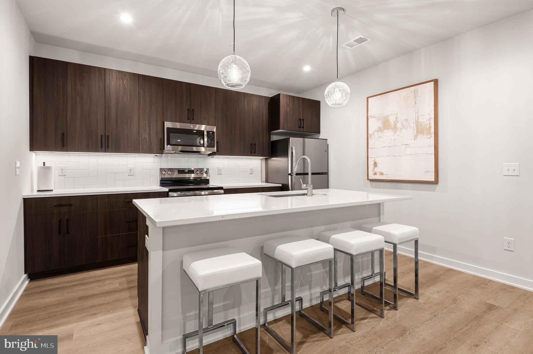 26 South York Road, Unit 101 Hatboro, PA 19040 - Photo 6 of 56 a kitchen with a dining table chairs and white cabinets