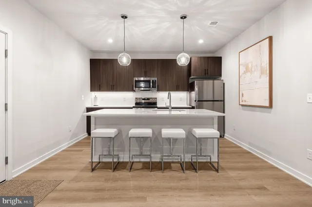 a kitchen with kitchen island a sink cabinets and stainless steel appliances