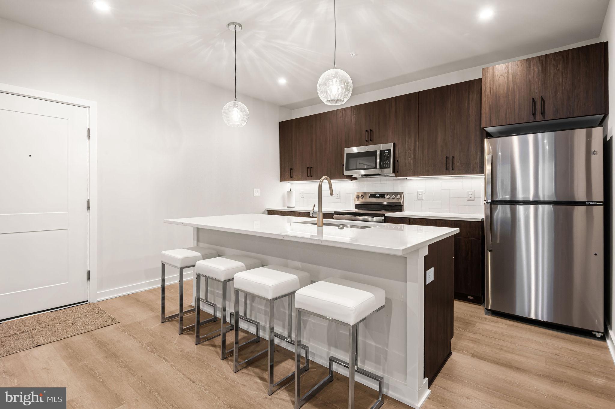26 South York Road, Unit 101 Hatboro, PA 19040 - Photo 8 of 56 a kitchen with kitchen island a sink cabinets and stainless steel appliances