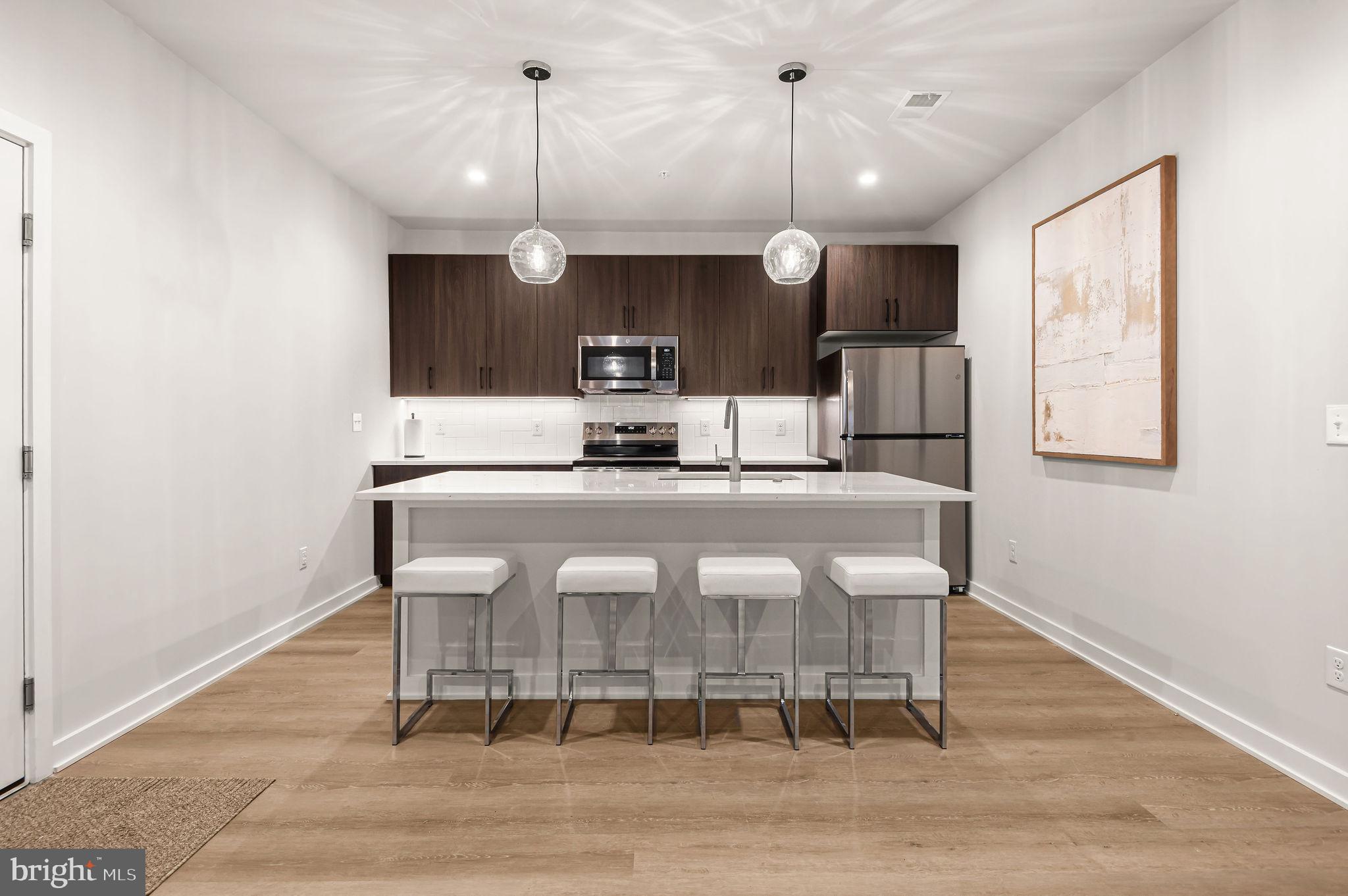 26 South York Road, Unit 101 Hatboro, PA 19040 - Photo 8 of 57 a kitchen with kitchen island wooden cabinets and refrigerator