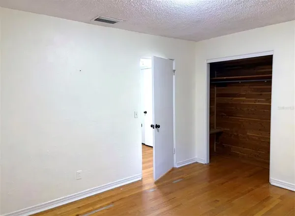 a view of an empty room with wooden floor