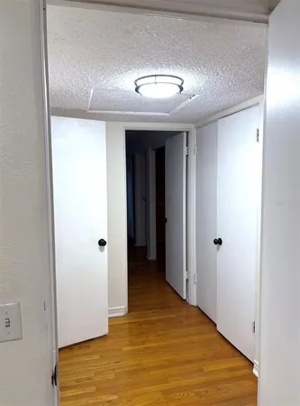 a view of a big room with wooden floor and cabinet