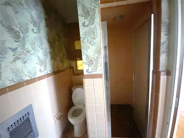 a bathroom with a toilet and a shower