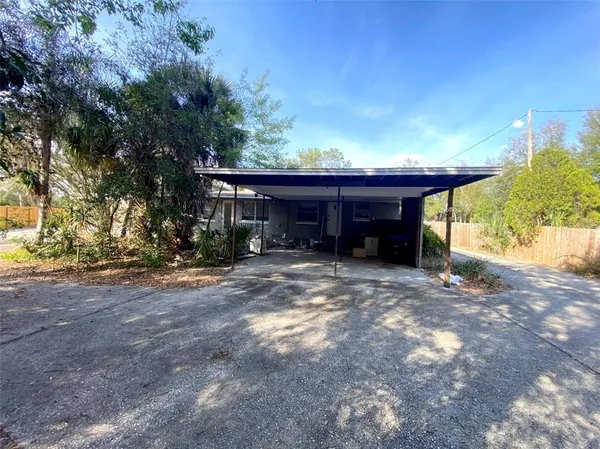a view of a house with backyard and trees