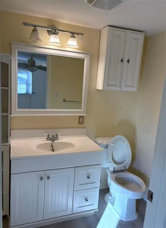 a bathroom with a toilet a sink and mirror
