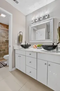 a bathroom with a granite countertop sink and a mirror