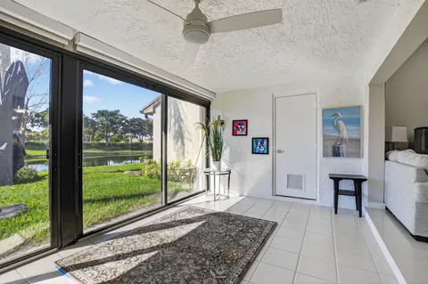a living room with a rug floor to ceiling window and a table
