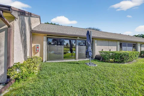 a view of a house with potted plants and a yard