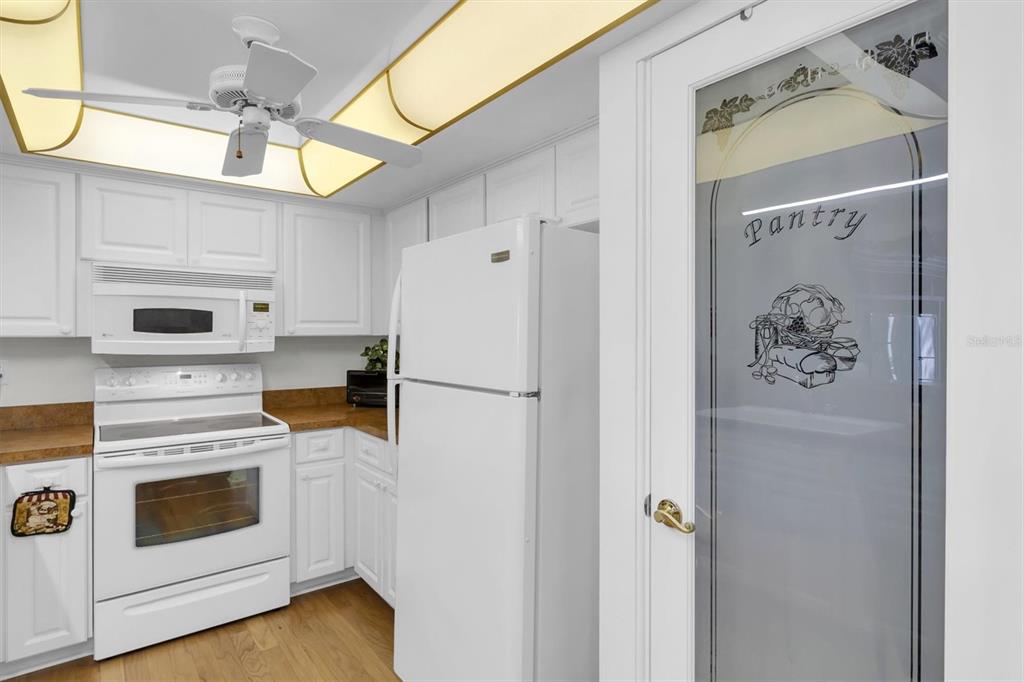 8141 Braddock Circle, Unit 3 Port Richey, FL 34668 - Photo 11 of 59 a kitchen with stainless steel appliances white cabinets and wooden floor