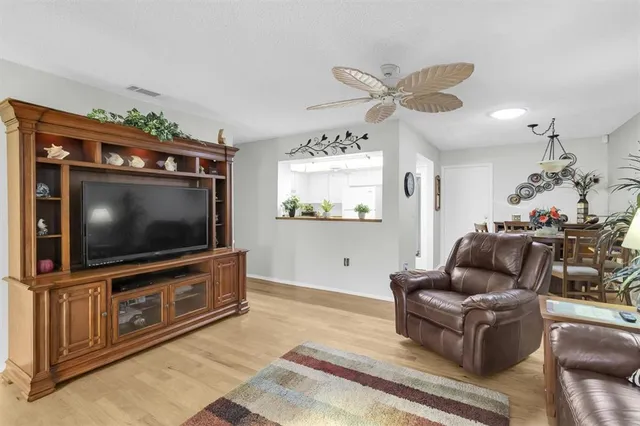 a kitchen with a sink dishwasher a stove and white cabinets with wooden floor