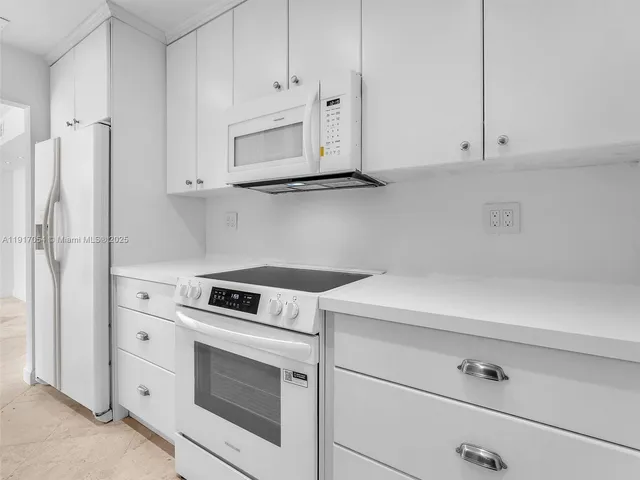 a kitchen with white cabinets and white appliances