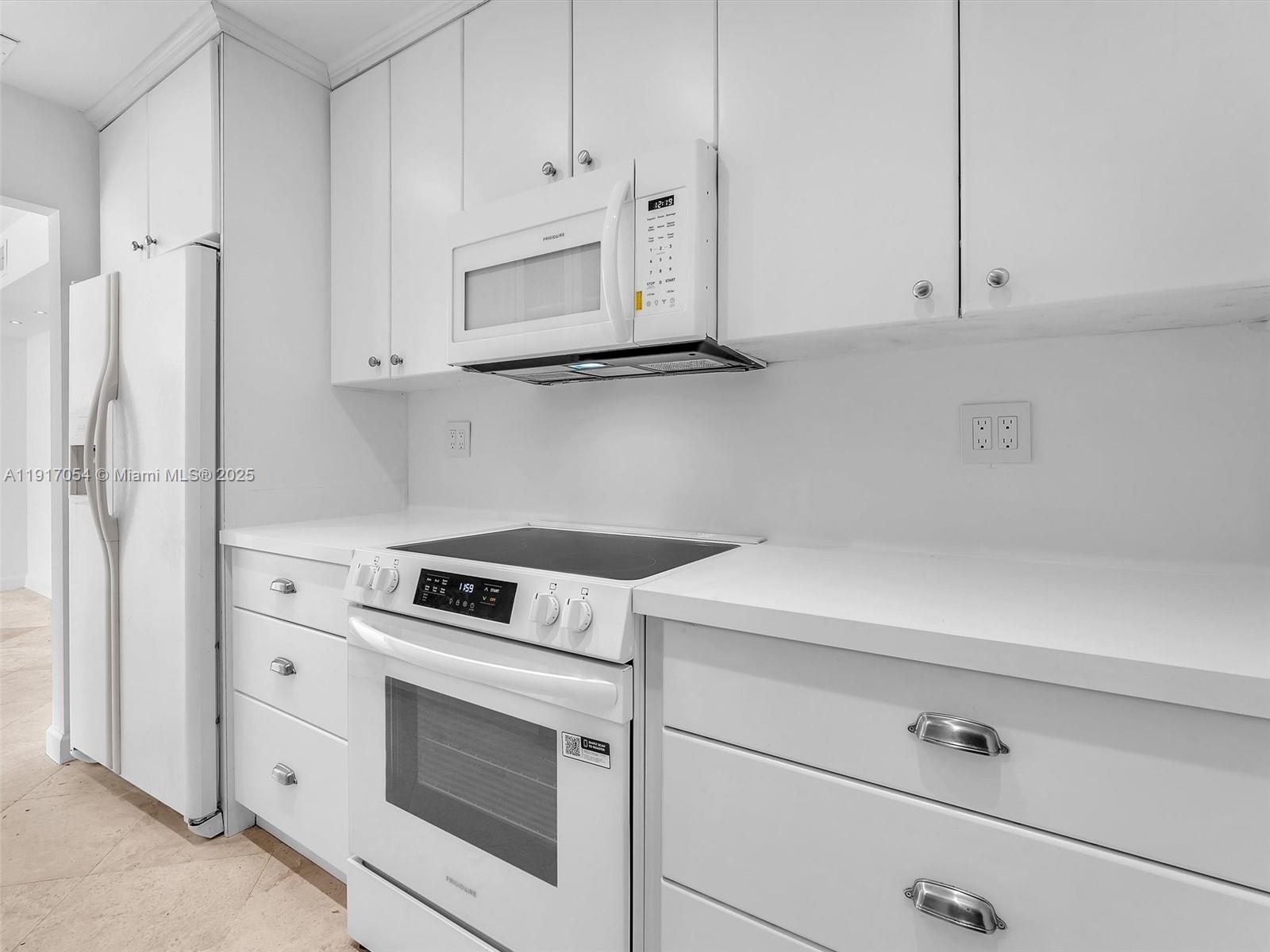 Key Biscayne Key Biscayne, FL 33149 - Photo 6 of 19 a kitchen with white cabinets and white appliances