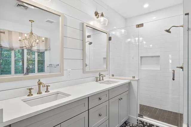 a bathroom with a sink a toilet a window and shower