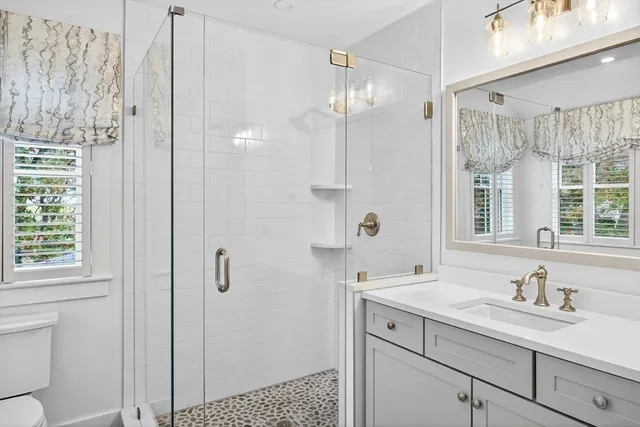 a bathroom with a sink a toilet and shower