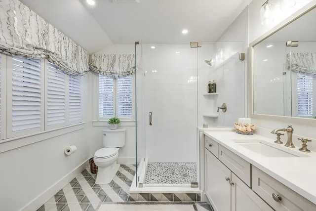 a bathroom with a sink a toilet and shower