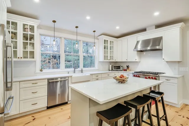 a kitchen with a dining table chairs refrigerator and cabinets