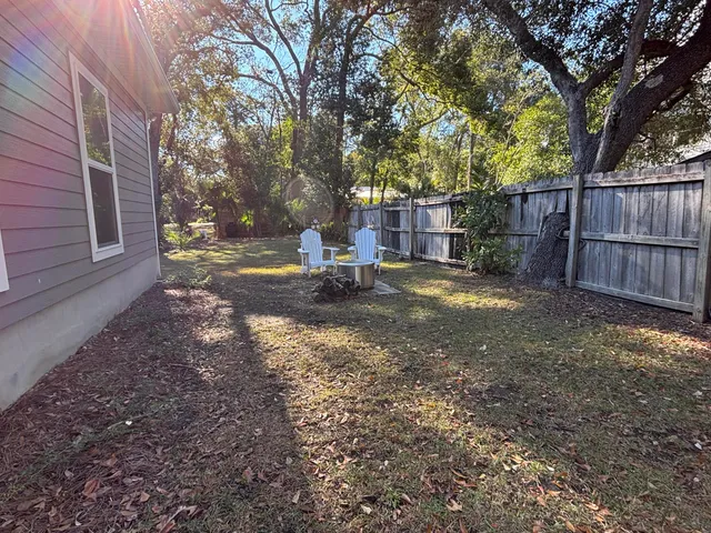 a view of a house with backyard and a tree