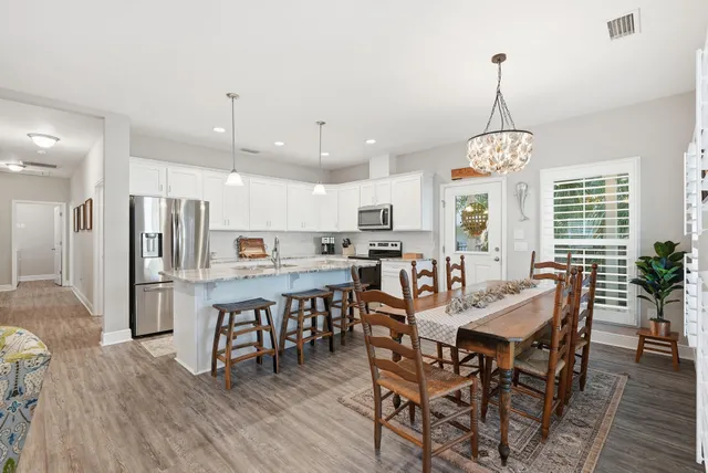 a kitchen with stainless steel appliances granite countertop white cabinets a stove top oven