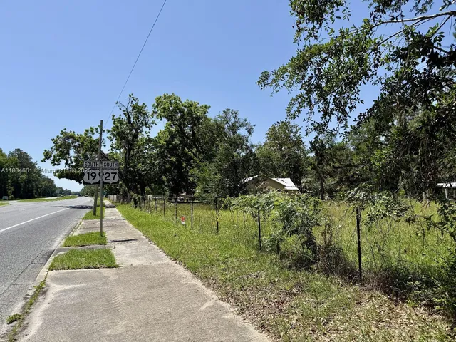 a sign board with grassy field