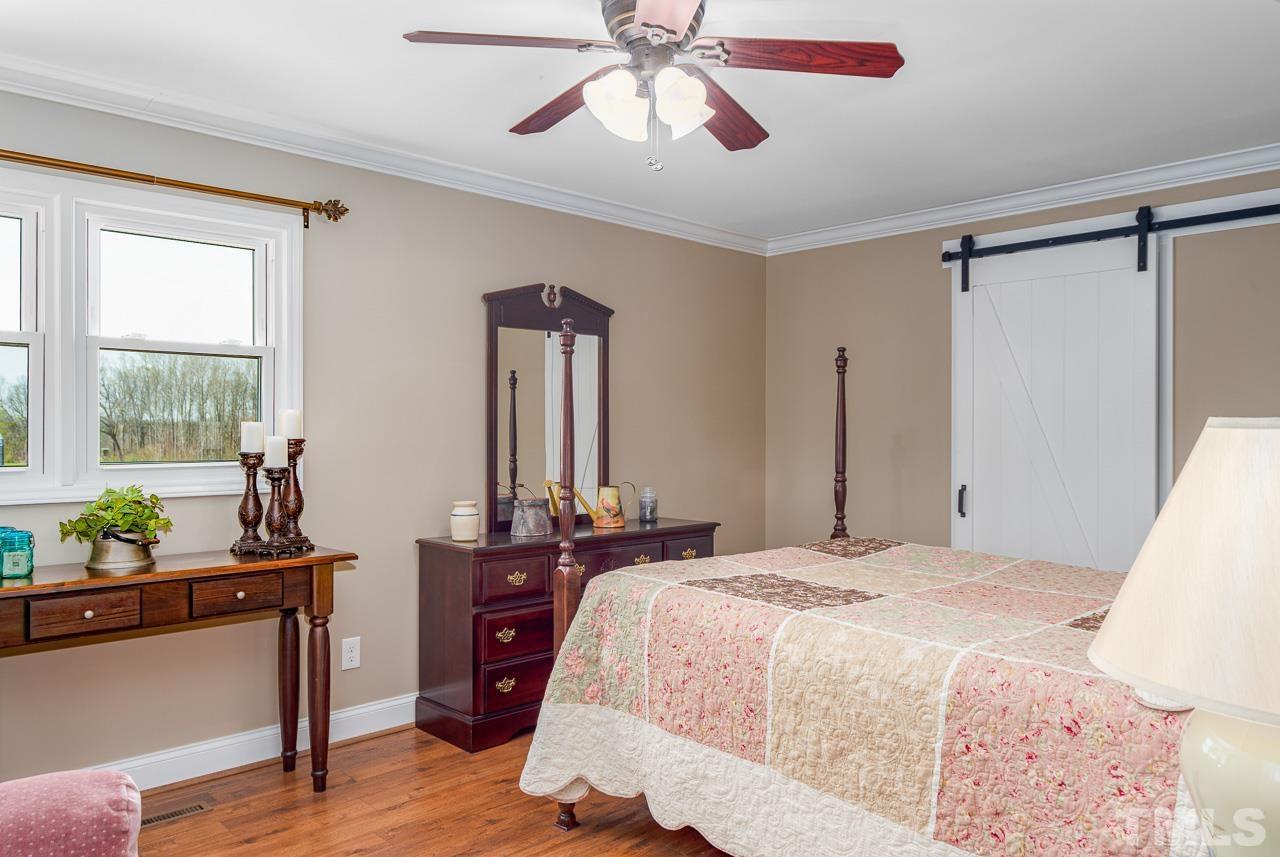 6668 Roby Coe Road Ramseur, NC 27316 - Photo 12 of 59 a bedroom with a bed and wooden floor