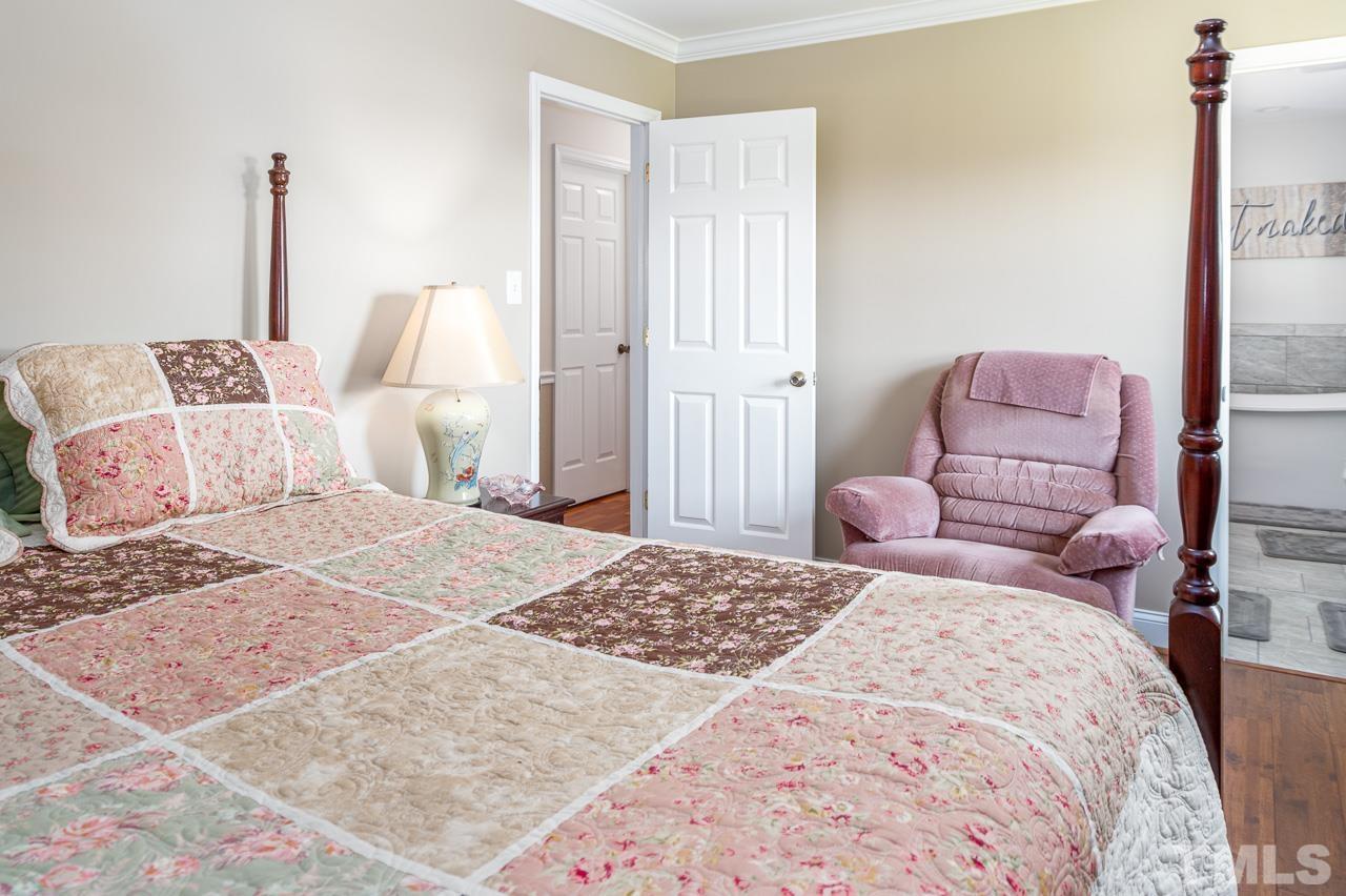6668 Roby Coe Road Ramseur, NC 27316 - Photo 13 of 59 a bedroom with a bed and wooden floor
