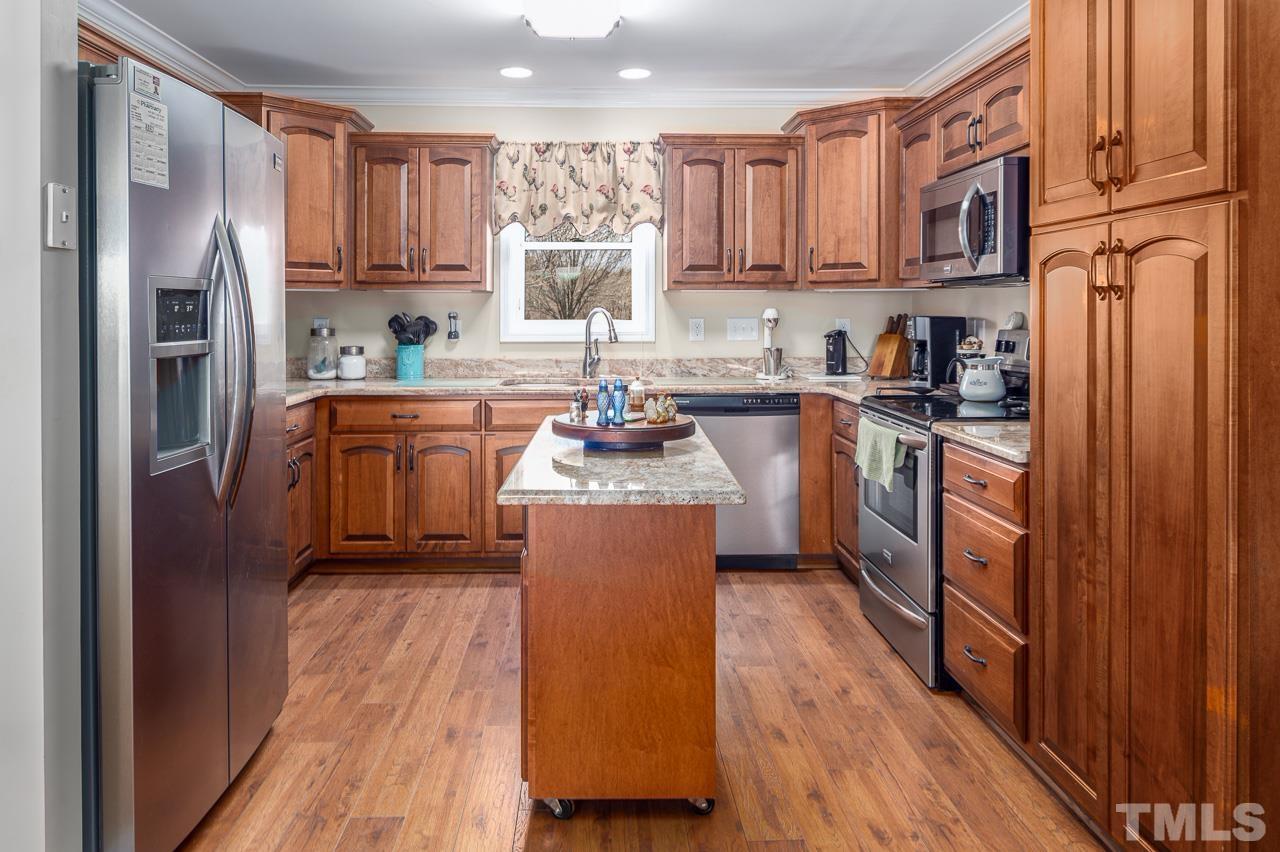 6668 Roby Coe Road Ramseur, NC 27316 - Photo 21 of 59 a kitchen with stainless steel appliances granite countertop a refrigerator a stove top oven a sink and dishwasher with wooden floor