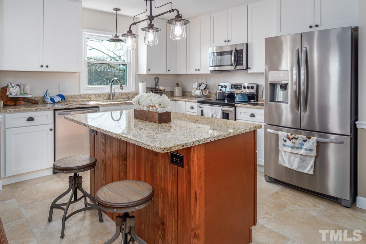 6668 Roby Coe Road Ramseur, NC 27316 - Photo 6 of 59 a kitchen with stainless steel appliances granite countertop a refrigerator a sink a stove a dining table and chairs
