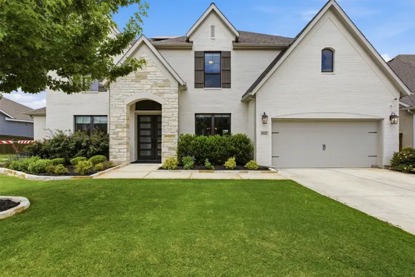a front view of a house with a yard and garage