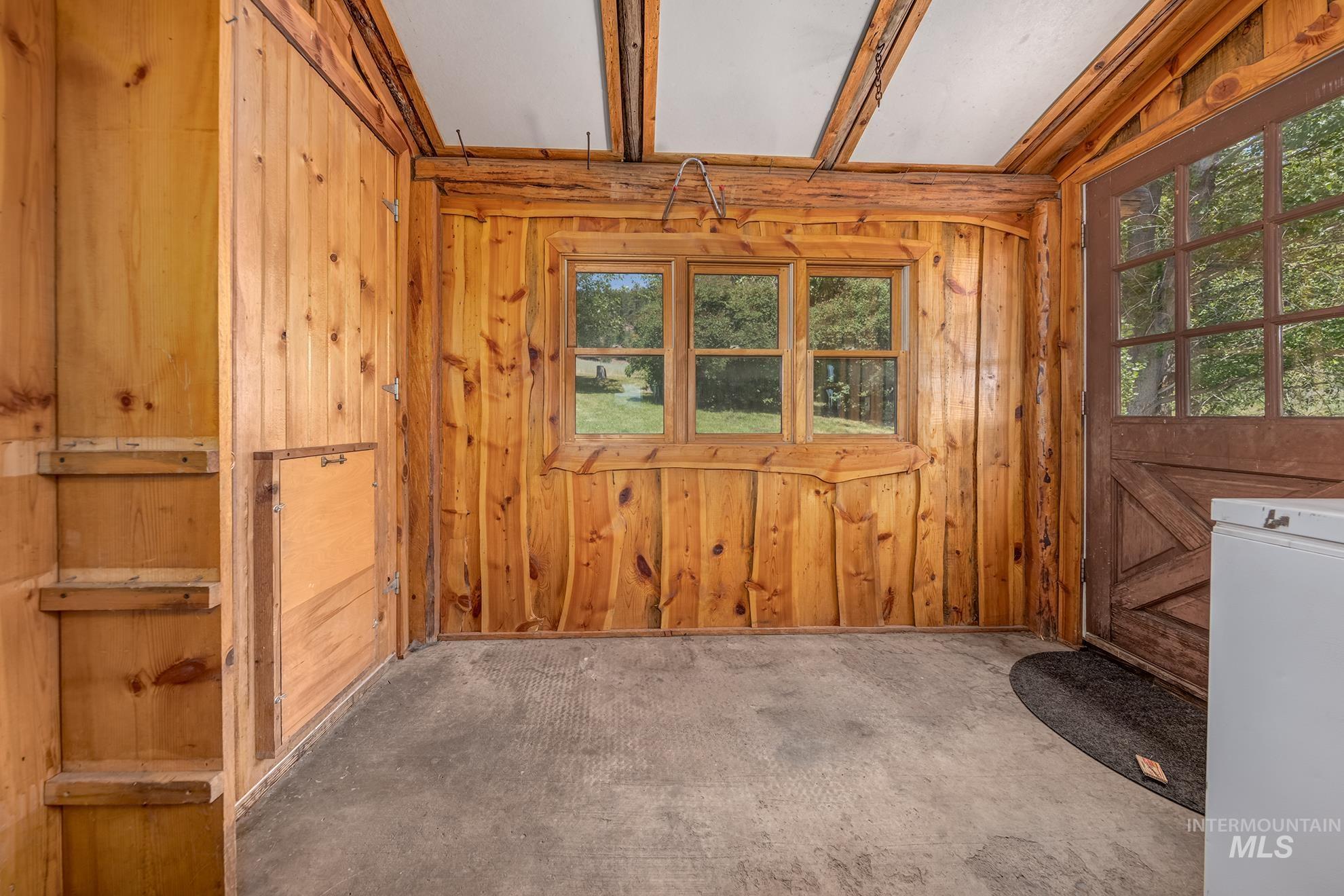 2150 Seid Creek Road Cambridge, ID 83610 - Photo 5 of 50 Interior space featuring natural wood paneling, exposed wood ceiling beams, a multi-pane window, and a wooden exterior door with glass inserts