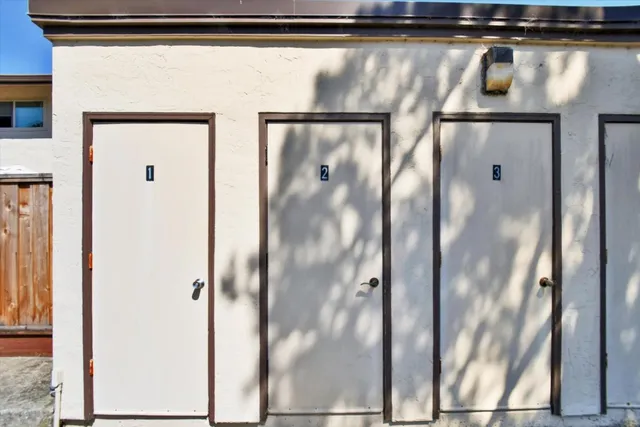 an aerial view of residential houses with outdoor space and trees