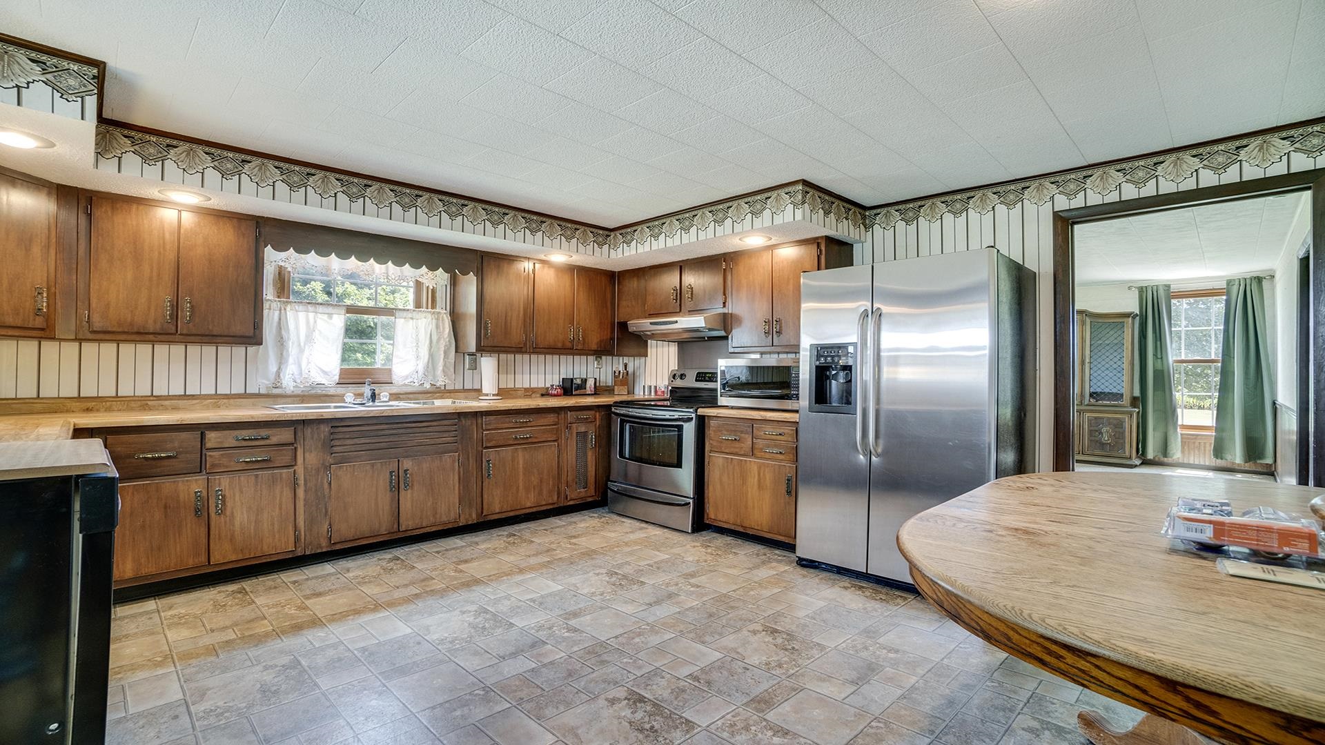 1813 Brooklyn Road Ashton, IL 61006 - Photo 11 of 43 a large kitchen with stainless steel appliances granite countertop a sink counter space cabinets and a large window