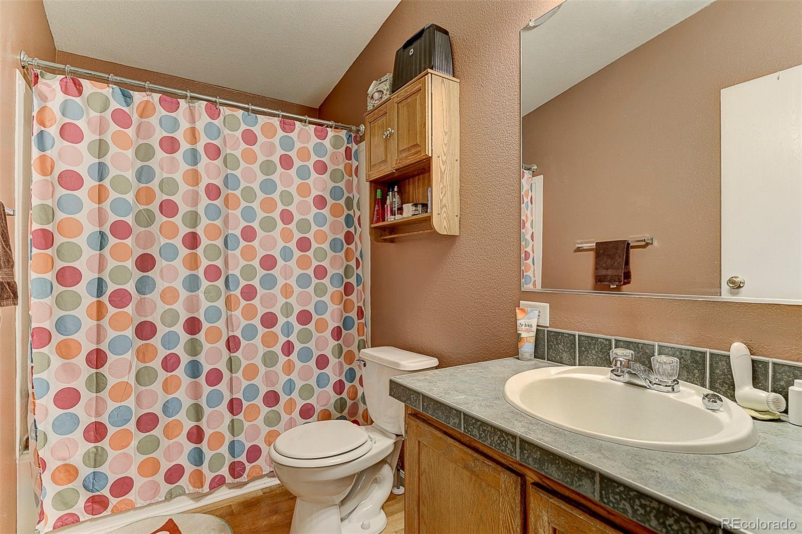 5255 North Yoder Road Yoder, CO 80864 - Photo 16 of 38 a bathroom with a granite countertop sink a toilet and a mirror