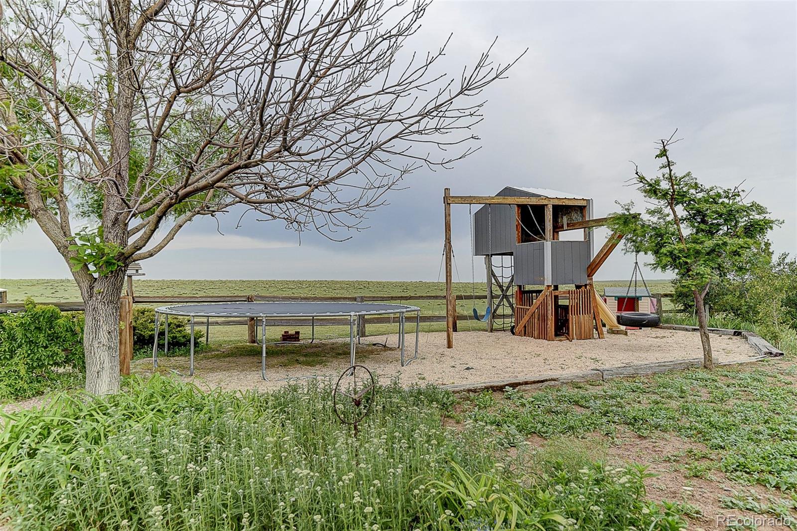 5255 North Yoder Road Yoder, CO 80864 - Photo 22 of 38 a backyard of a house with table and chairs