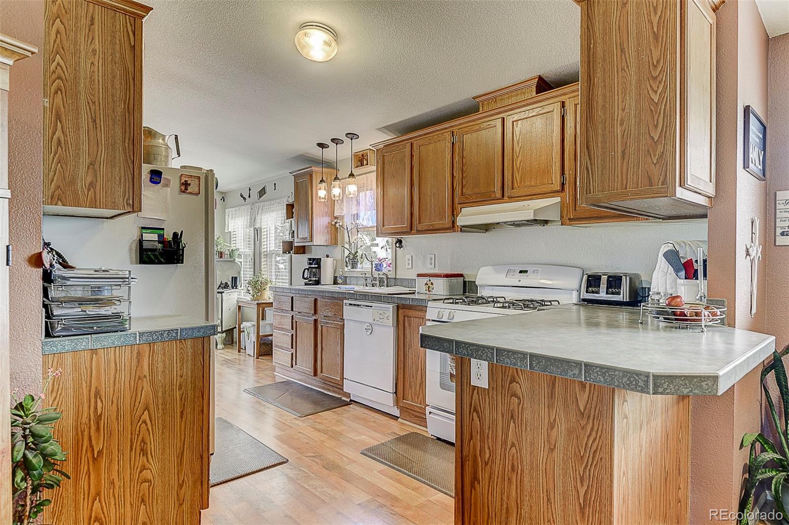 5255 North Yoder Road Yoder, CO 80864 - Photo 7 of 38 a kitchen with stainless steel appliances granite countertop a stove a sink dishwasher and a refrigerator with cabinets