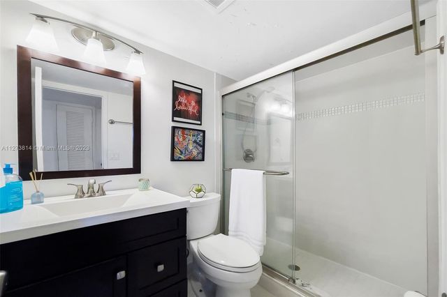 a bathroom with a sink a toilet a shower and a mirror