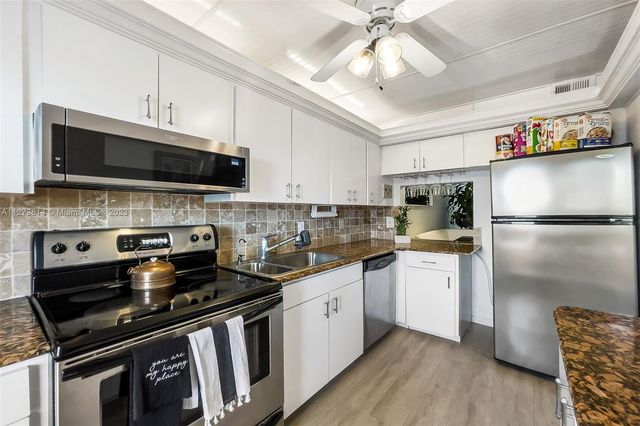 a kitchen with stainless steel appliances a stove a sink and a refrigerator