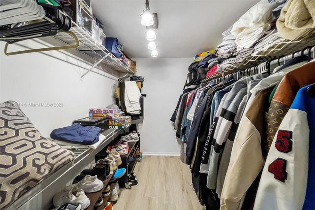 a view of walk in closet with clothes and shoes