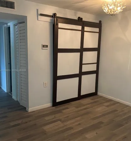 a view of a room with wooden floor and windows