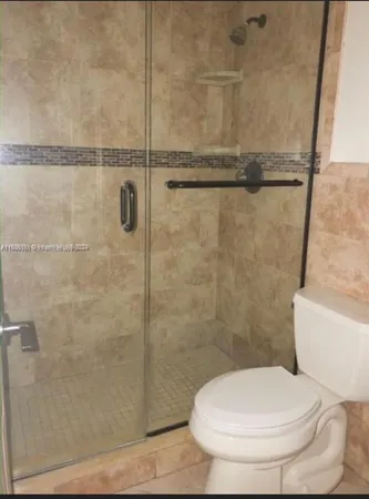 a bathroom with a toilet and a shower