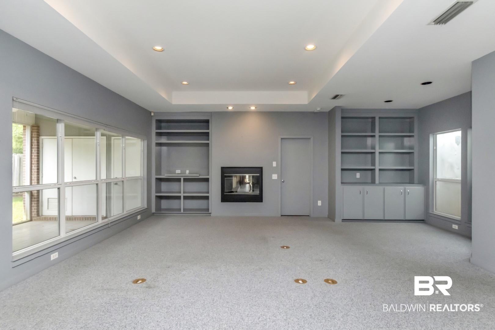 1205 Hillcrest Crossing East Mobile, AL 36695 - Photo 12 of 40 Unfurnished living room featuring light carpet, built in shelves, and a raised ceiling