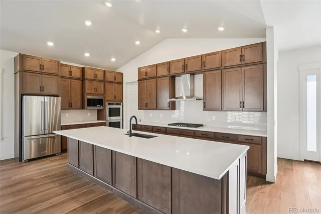 a kitchen with stainless steel appliances a sink stove and refrigerator