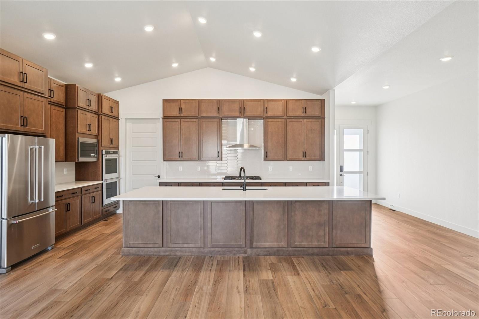 1738 Morningstar Way Fort Collins, CO 80524 - Photo 12 of 47 a large kitchen with stainless steel appliances a large counter top a sink and a refrigerator